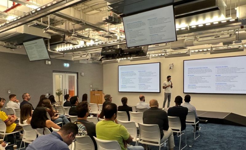 Aazim on stage between two screens at the Data to Decisions event