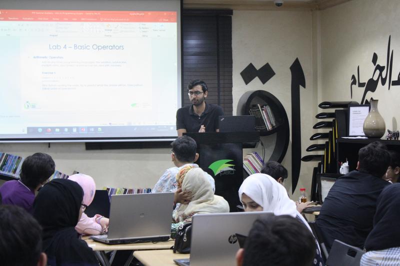 Aazim leading an intro-to-programming workshop for the Pakistan Youth Forum, students at laptops